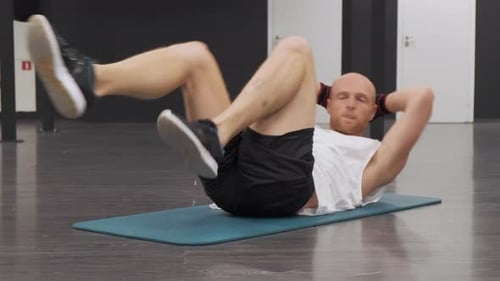 Junger europäischer Mann treibt Sport, trainiert Bauchmuskeln im Fitnessstudio und trainiert Selbstentwicklung