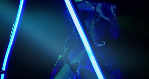 Stylish Woman Posing with Neon Lights in Dark