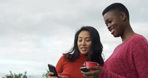 Two Friends Using Phones Outside