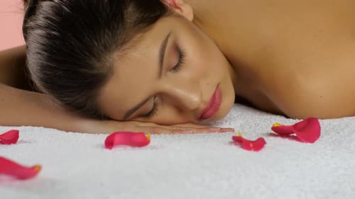 Girl Sleeps After Spa Treatments on Towels with Rose Petals
