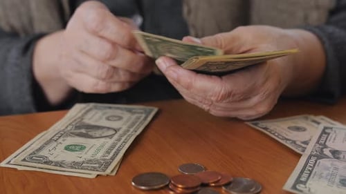 Mujer mayor contando los últimos ahorros