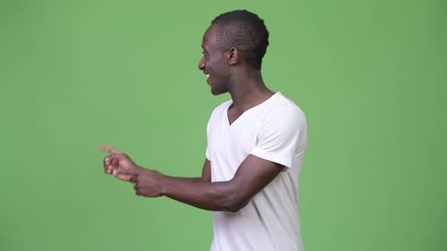 Young Man Points on Green Screen Background