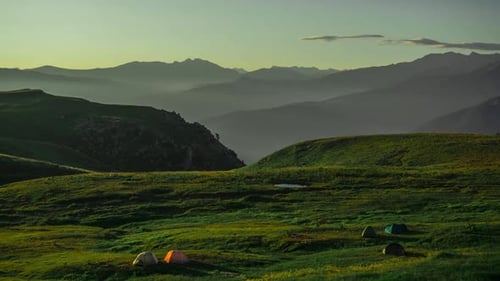Beschleunigte Luftaufnahme der wunderschönen Landschaft eines mit Gras bedeckten Berges, Touristen