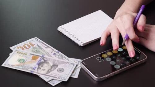 Woman Calculates Finances on Smartphone Calculator