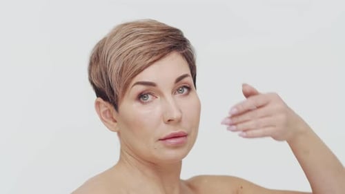 Close-up of middle aged mature woman over white background.
