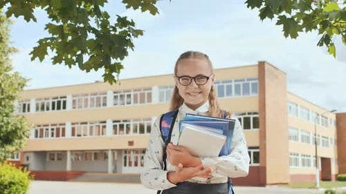 Portrait of Smiling School Girl Child with Backpack and Books.