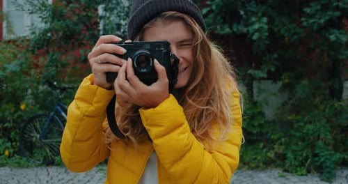 Smiling Woman Taking Photos with Classic Camera