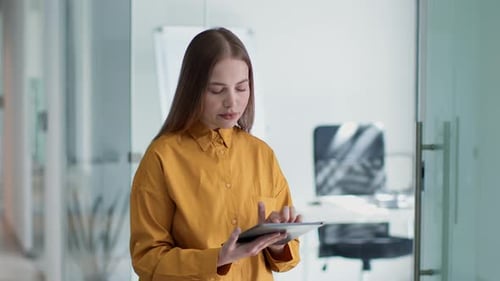 Young Thoughtful Professional Woman Manager Chatting Online Thinking and Typing on Digital Tablet