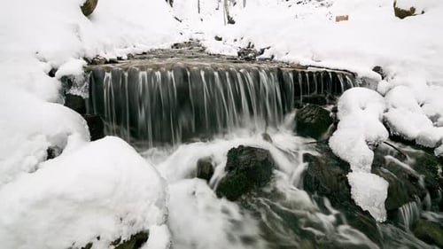 Wonderful Frozen Foot of a Waterfall with a Powerful Stream of Water at Winter Carpathian Mountains