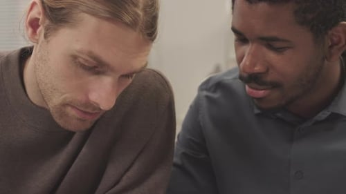 Multiethnic Coworkers Analyzing Financial Documents in Office