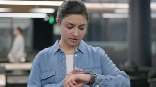 Woman Uses Smartwatch Technology in Office Setting