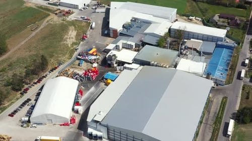 Modern factory in the countryside. Huge industrial complex among picturesque green fields. New manuf