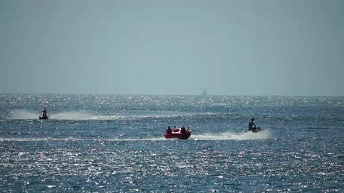 People Enjoying Water Sports on a Sparkling Sea
