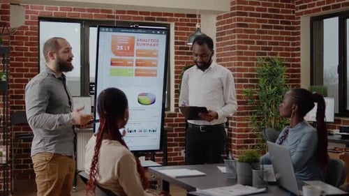 Diverse Colleagues Reviewing Data Analytics in Office