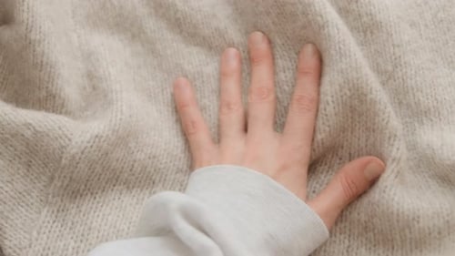 Hand Touching Soft, Neutral Knitted Sweater Fabric
