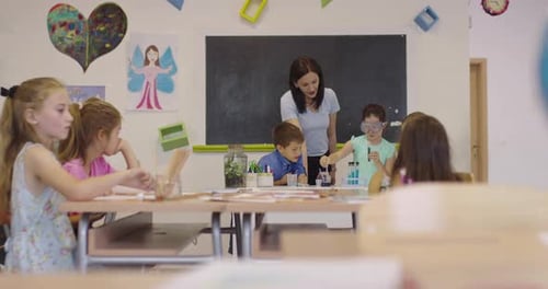 Elementary School Science Classroom Enthusiastic Teacher Explains Chemistry to Diverse Group of