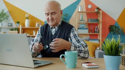 Senior Adult Typing on Laptop at Home