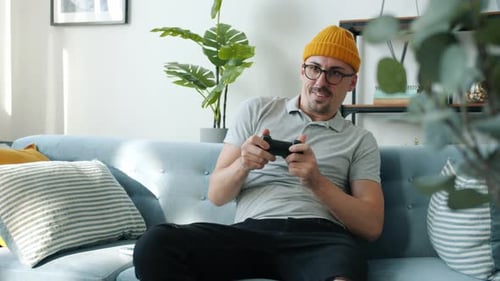 Excited Man Playing Video Games on Couch