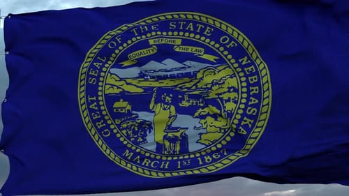 Nebraska State Flag Waving Against Cloudy Sky