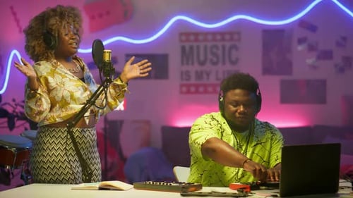 Black Woman Recording Song with DJ in Audio Studio