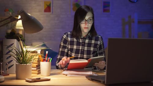 Focused Woman Studying Late at Night With Laptop