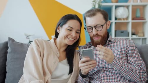 Smiling Couple Enjoying Smartphone Content Together