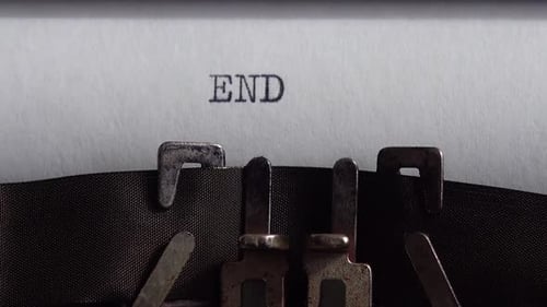 Typing word End on retro typewriter. Close up.