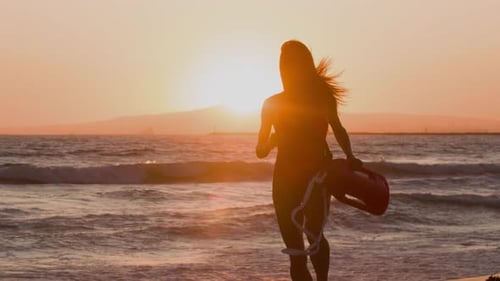 Female lifeguard running along the beach
