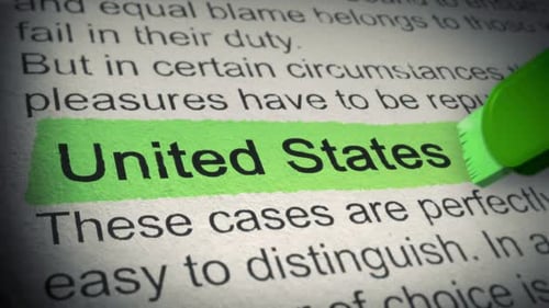 United States of America. Highlighter pen marks word in Newspaper. Closeup. Thumbing pages and promo