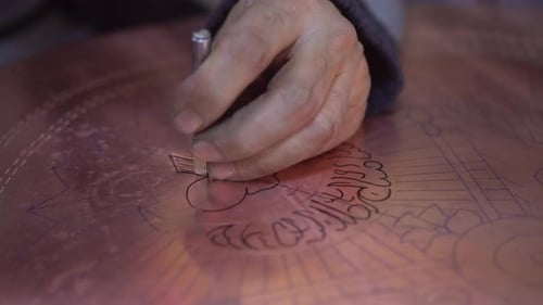 Artist Engraving Intricate Design in Metal