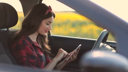 Woman Using Smartphone in Car near Field