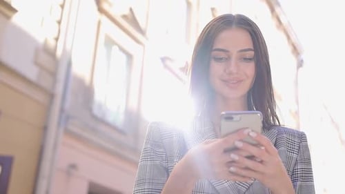 Beautiful Woman Using Mobile Phone On Street