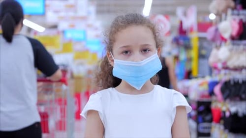 Young Child Wearing Mask in Supermarket Aisle