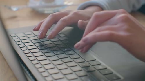 Woman Typing on Laptop Keyboard in the Office. Close Up Woman Hands Writing on Laptop Computer