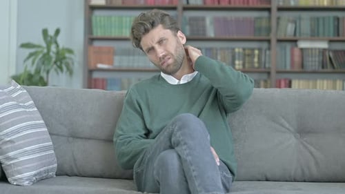 Young Adult Man Massaging His Neck Due to Pain