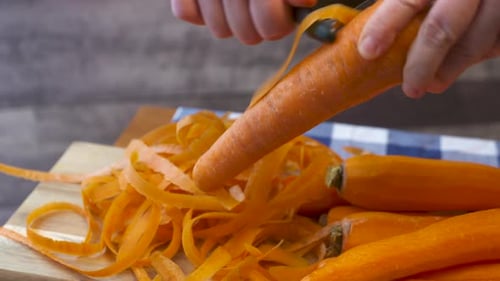 Peeling Carrots on Wooden Cutting Board