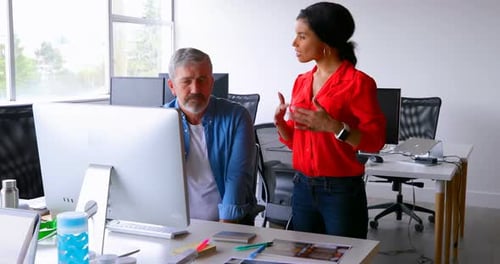 Colleagues Collaborate at Computer in Modern Office