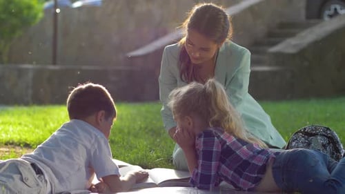 Child Development, Young Woman Read Interesting Book for Kids Sitting on Green Lawn in Nature in