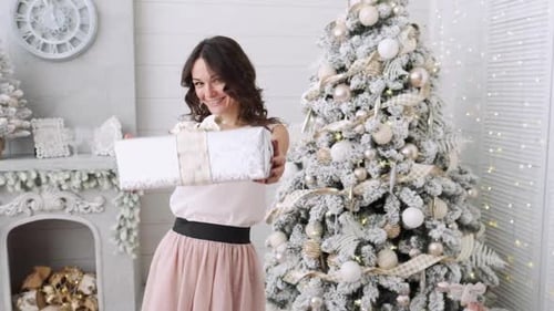 Smiling Woman Offering a Christmas Gift