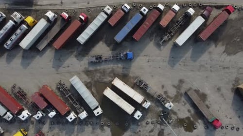 Aerial View of a Parking Lot of Trucks Ready for Loading Containers and Delivery