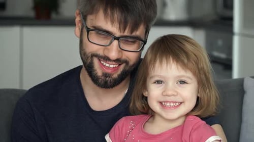 Dad and Daughter Smiling on Couch Close Up