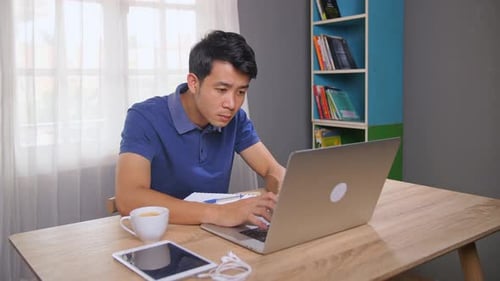 Man Working on Laptop Looks Stressed and Frustrated