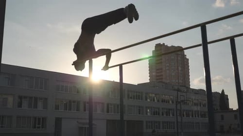 Man Doing Handstand on Parallel Bars in Urban Setting