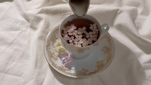 Side View of a Person Pouring Tea in Cup with Flower