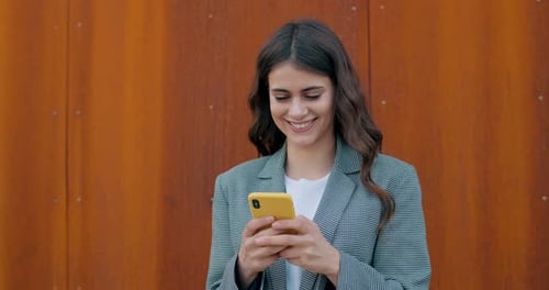Smiling Woman Using Cellphone Outdoors in City