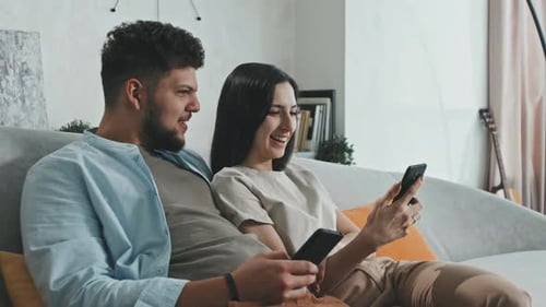 Couple Relaxing with Smartphones on Couch