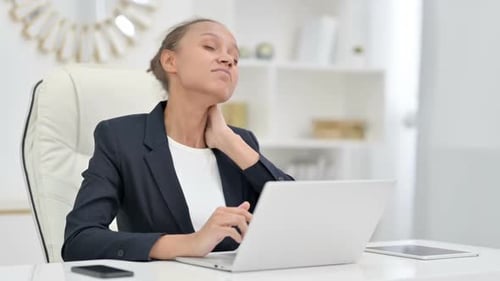 Tired African Businesswoman with Laptop Having Neck Pain in Office