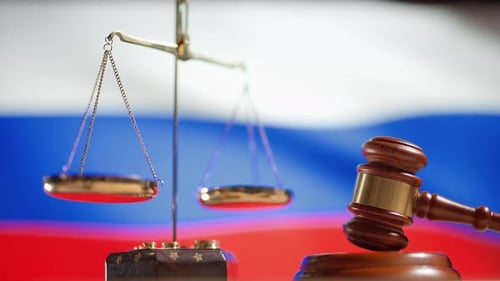 Um martelo de juiz com uma bandeira da Rússia em segundo plano