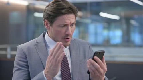 Concerned Man Reacts to News on Smartphone