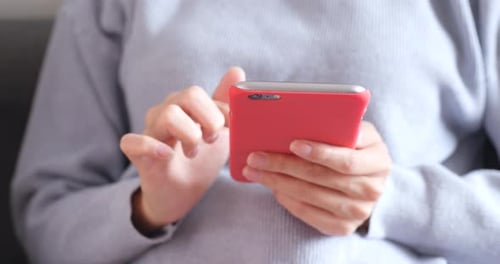 Person Using Smartphone with Red Case